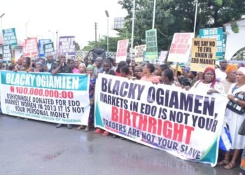 *Placard-carrying market men and women protesting at the Palace of the Oba of  Benin against Madam Blacky Ogiamen